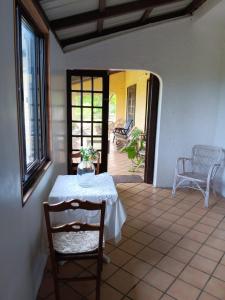 a table and chairs in a room with a patio at Acacia Retreat in Île La Fond