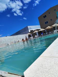 a swimming pool in front of a hotel with people in it at Marechal Plaza Hotel in São Gabriel