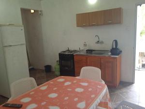 a kitchen with a table and a stove and a refrigerator at Los Cali 27 planta alta 1 in Balneario Buenos Aires +1 photo