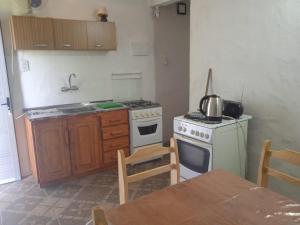 a kitchen with a stove and a sink and a table at Los Cali 27 planta alta 1 in Balneario Buenos Aires