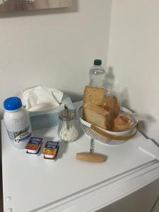 a counter with a basket of bread and a bottle of water at Maison les étoiles in Hésingue +3 photos