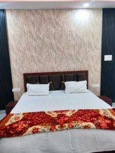 a bedroom with a large bed with a floral blanket at Kamadgiri Green Valley in Nawābganj +3 photos
