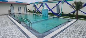 a large swimming pool with chairs in the water at Kamadgiri Green Valley in Nawābganj