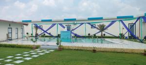 a bridge over a swimming pool in front of a building at Kamadgiri Green Valley in Nawābganj