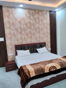 a bedroom with a large bed and a wall at Kamadgiri Green Valley in Nawābganj