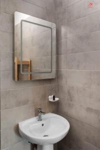a bathroom with a sink and a mirror at Apartament 2 dormitoare spatios, Aer conditionat, Flat Screen TV, Self Check-in in Ştefăneştii de Sus +22 photos