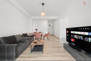 a living room with a couch and a tv at Apartament 2 dormitoare spatios, Aer conditionat, Flat Screen TV, Self Check-in in Ştefăneştii de Sus