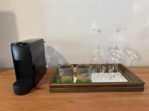 a tray with two glasses and a phone next to a phone gmaxwell gmaxwell gmaxwell gmaxwell at Vilarejo Ibitipoca in Conceição da Ibitipoca