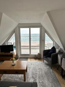 a living room with a view of the beach at Mariners Hotel in Seaton
