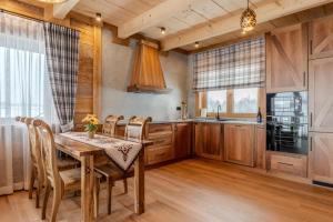 a dining room with a table and chairs and a kitchen at Domki Góralska Przystań in Białka Tatrzańska +31 photos