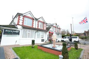 a house with a fountain in front of a street at Acorn Lodge Hotel Gatwick & Parking in Horley