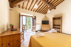 a bedroom with a bed and a desk and a tv at Villa Montarioso in Siena