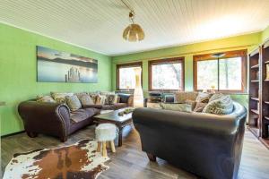 a living room with leather couches and windows at KRO906-Lidhult-Torseryd-4 in Lidhult