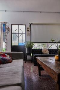 a living room with couches and a table and a window at Ramallo es Bienestar 8 plazas in Ramallo