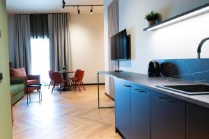 a kitchen with blue cabinets and a living room at A1 Stuudiod in Rakvere