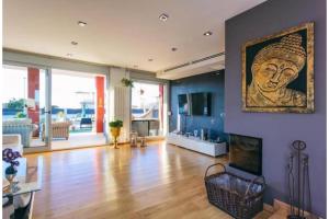 a living room with a painting of a head on the wall at Red House Rooms in Llucmajor