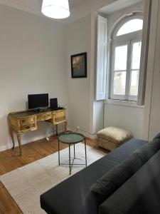 a living room with a couch and a desk at Sintra Flower Camelia Apartment in Sintra