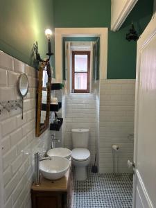 a green and white bathroom with a toilet and a sink at Sintra Flower Camelia Apartment in Sintra +23 photos
