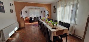 a dining room with a long table and chairs at Vila Dascalita in Moieciu de Sus