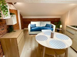 a living room with a blue couch and a table at Capitole Hyper-centre, Mezzanine & confort in Toulouse