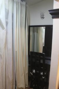 a room with a mirror and a curtain and a chair at Villas Tecuanapan in Xalapa