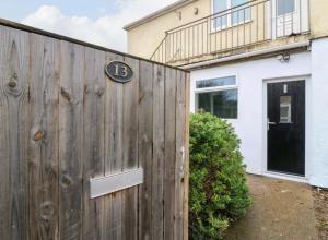 a house with a wooden fence with a number on it at High Tide in Whitstable