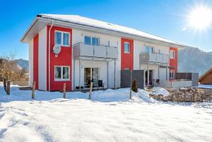 a red and white house in the snow at Ferienwohnungen Apart Diana in Vils