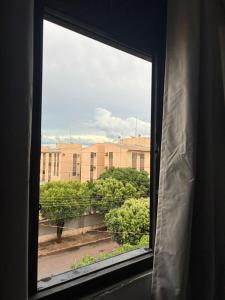 a window with a view of a building at Proximo ao Shopping e Aeroporto 2 Quartos com Ar e TV a Cabo in Várzea Grande