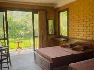 a bedroom with a bed and a balcony at Rainforest Royal Heritage in Deniyaya