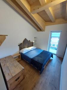 a bedroom with a bed and a wooden table at Appartamento LINKE in Cogolo