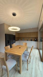 a dining room with a wooden table and chairs at Apartament Cisza Leśna in Gołubie