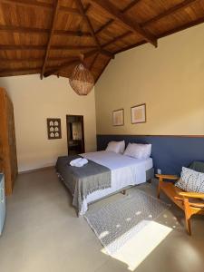 a bedroom with a bed and a table in it at Vilarejo Ibitipoca in Conceição da Ibitipoca