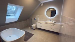 a bathroom with a white sink and a mirror at Apartament Cisza Leśna in Gołubie +5 photos