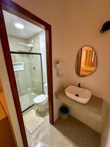 a bathroom with a sink and a toilet and a mirror at Pousada Brisa Mar in Fernando de Noronha