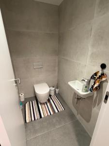 a small bathroom with a toilet and a sink at Sky Park by MISSONI in Nivy
