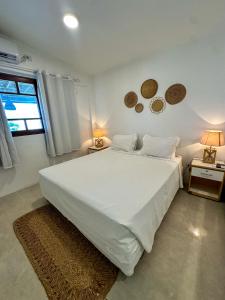 a bedroom with a large white bed and a window at Pousada Brisa Mar in Fernando de Noronha