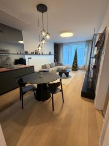 a living room with a table and a christmas tree at Sky Park by MISSONI in Nivy +2 photos