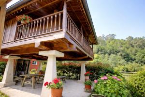 a deck on a house with flowers in pots at Casa con Jardín y Barbacoa en Llanes – Molinin in Villanueva de Ardisana +37 photos