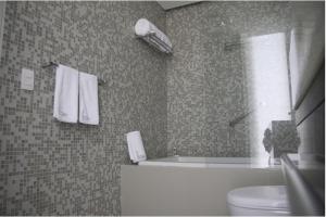 ein Badezimmer mit Badewanne, Toilette und Fenster in der Unterkunft Hotel 286 in Ciudad Guayana