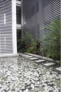 ein Garten mit Steinen auf dem Boden vor einem Gebäude in der Unterkunft Hotel 286 in Ciudad Guayana + 22 Fotos