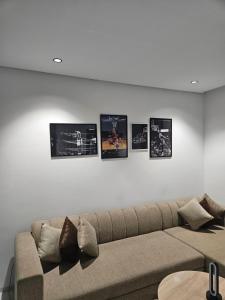 a living room with a couch and four pictures on the wall at loft in El Aouina Station