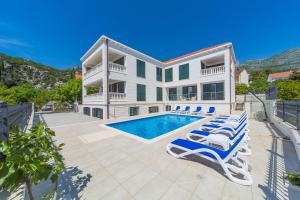 a house with a swimming pool and lounge chairs at Villa Slano in Slano