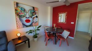 a living room with a table and a red wall at Casa Nina Novastar in San Pedro del Pinatar +35 photos