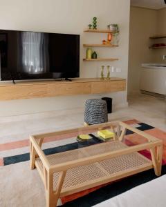 a living room with a coffee table and a flat screen tv at Villette Serviced Apartments in Sodic New Cairo in New cairo