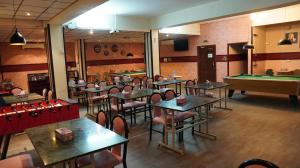 a dining room with tables and a pool table at Hotel Summersands Al Wadi Al kabir in Muscat