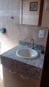 a bathroom with a sink and a glass shower at Lindo Flat no Centro de Caxambu in Caxambu +11 photos