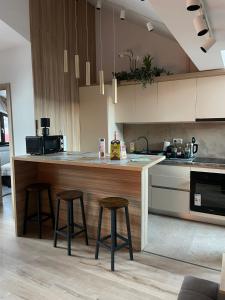 a kitchen with a counter and two bar stools at Marova Luxury Loft Caraiman View in Buşteni