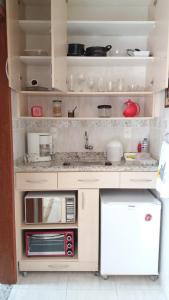 a kitchen with a sink and a microwave at Lindo Flat no Centro de Caxambu in Caxambu