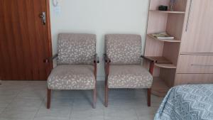 two chairs sitting next to each other in a room at Lindo Flat no Centro de Caxambu in Caxambu