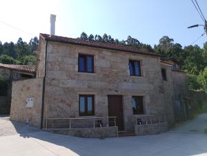 an old stone house with black windows at Eira de Mantoño in Mantoño